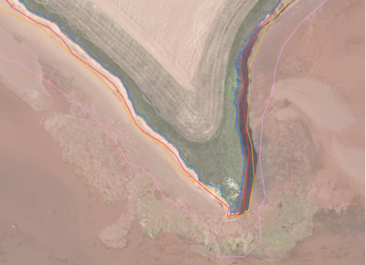 Aerial view of a coastline with multiple colored lines traced along the shore to track and delineate historical coastline positions.